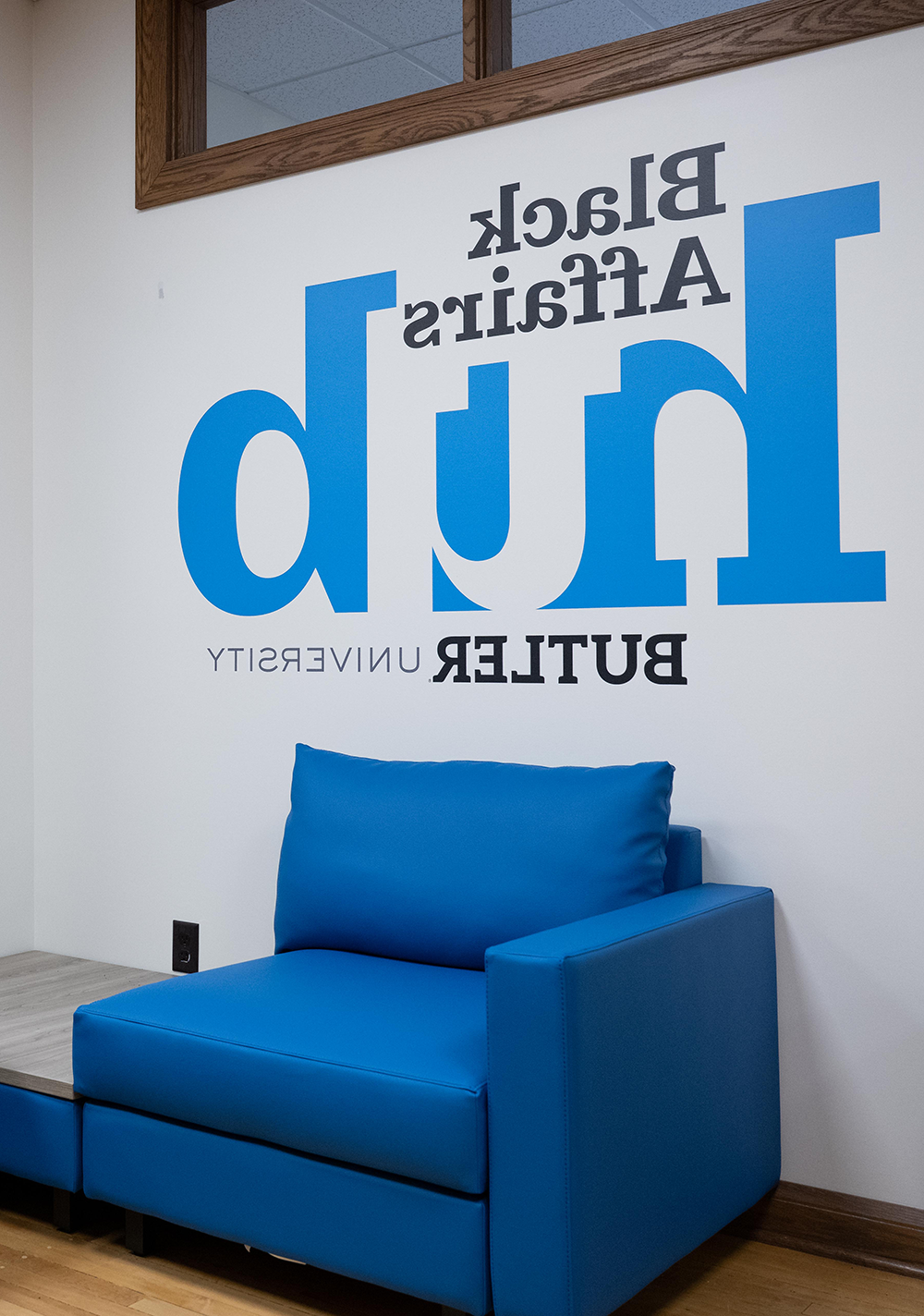 蓝色椅子后面的墙上印着黑人事务中心亚洲博彩平台排名的字样.